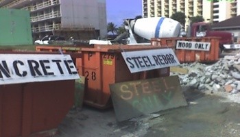 labeled large waste containers at a construction site