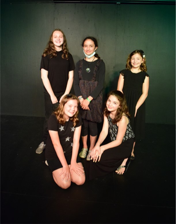 small group of theater students posing on stage