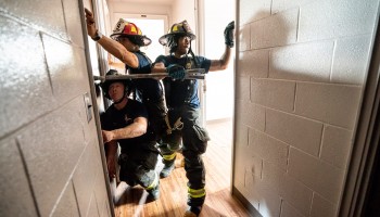 Nashville Fire Department Suppression team working to break down door inside building