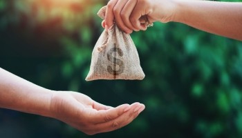 hand passing a bag of money to another person