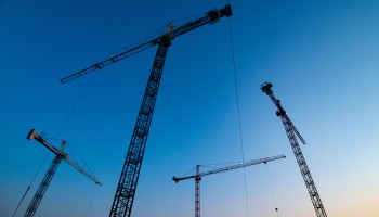construction cranes in the sky at dusk