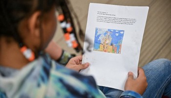 child reading a paper