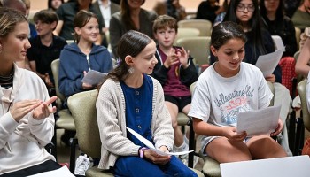 group of children sitting in an audience
