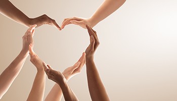 photo: group of people holding their hands to form a heart symbol