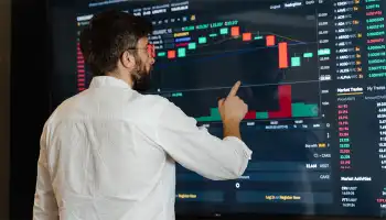 person touching large screen showing charts