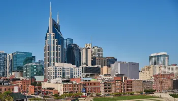 Nashville skyline with downtown buildings and tower under clear blue sky.