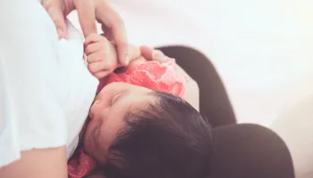 Parent and child holding hands in warm embrace, close-up view.