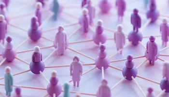 Purple and blue figurines connected by lines on white surface, representing network or social connections.