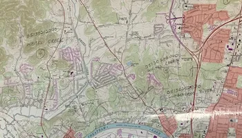 Topographic map showing urban and rural areas with roads, contour lines, and a blue waterway.