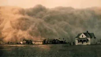Massive dust storm approaches farm buildings and houses across flat prairie landscape.