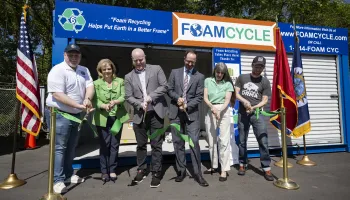 People cutting a ribbon at the foam densifier unit