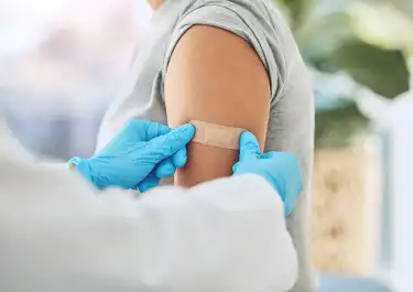 photo of doctor applying a band-aid after giving a shot