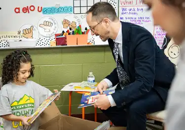 Mayor Freddie O'Connell looking at books with a child in a classroom