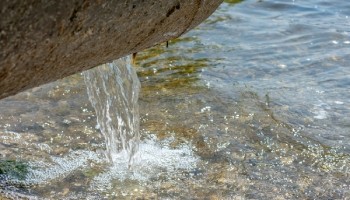 water coming out of a pipe into the water