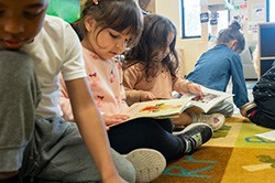young children reading books on the floor