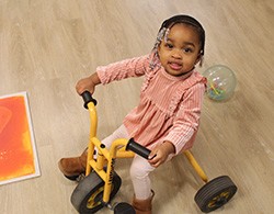 smiling infant on a tricycle