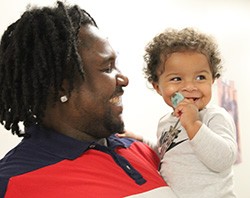 man holding infant, both smiling