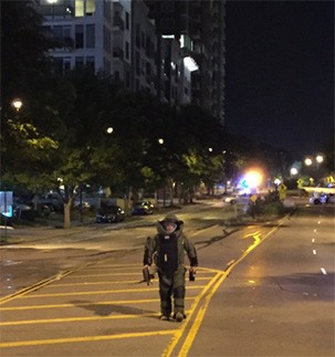 Officer in Hazardous Devices uniform walking down street at night