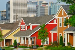 Photo of colorful houses in the foreground and skyscrapers in the background