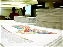 Photo showing a map document in the foreground and people in the background