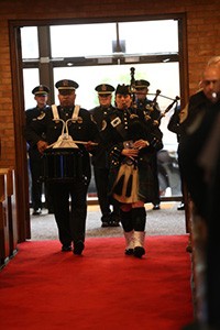 Photo of Metro Police bagpipers marching down aisle