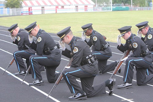 Metro Police Riflemen kneeling and saluting