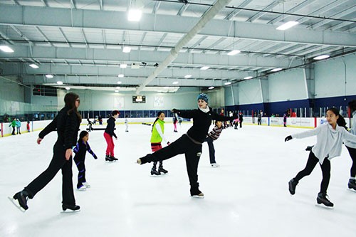 Photo of several individuals ice skating on on indoor rink