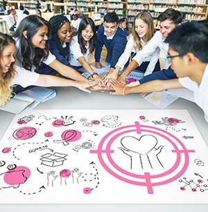 group of teen creating activities with hands together around the table