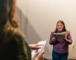 Young girl reading from a script