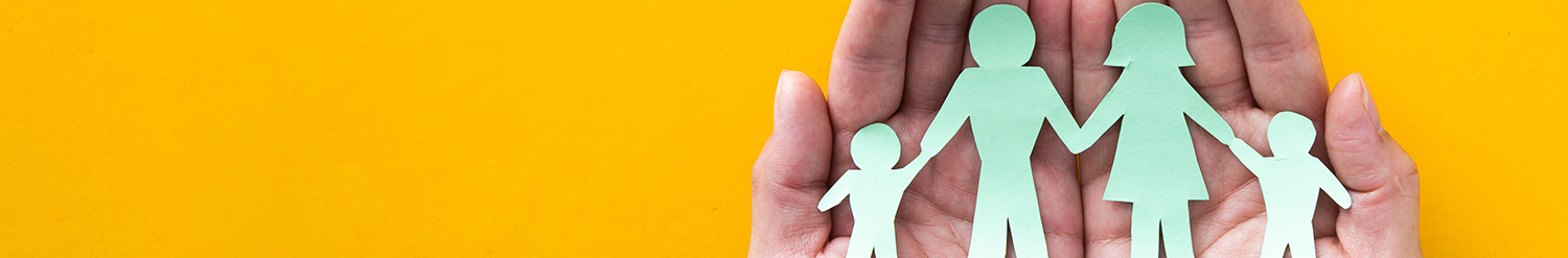 Photo of a pair of hands holding a paper cut out of a family