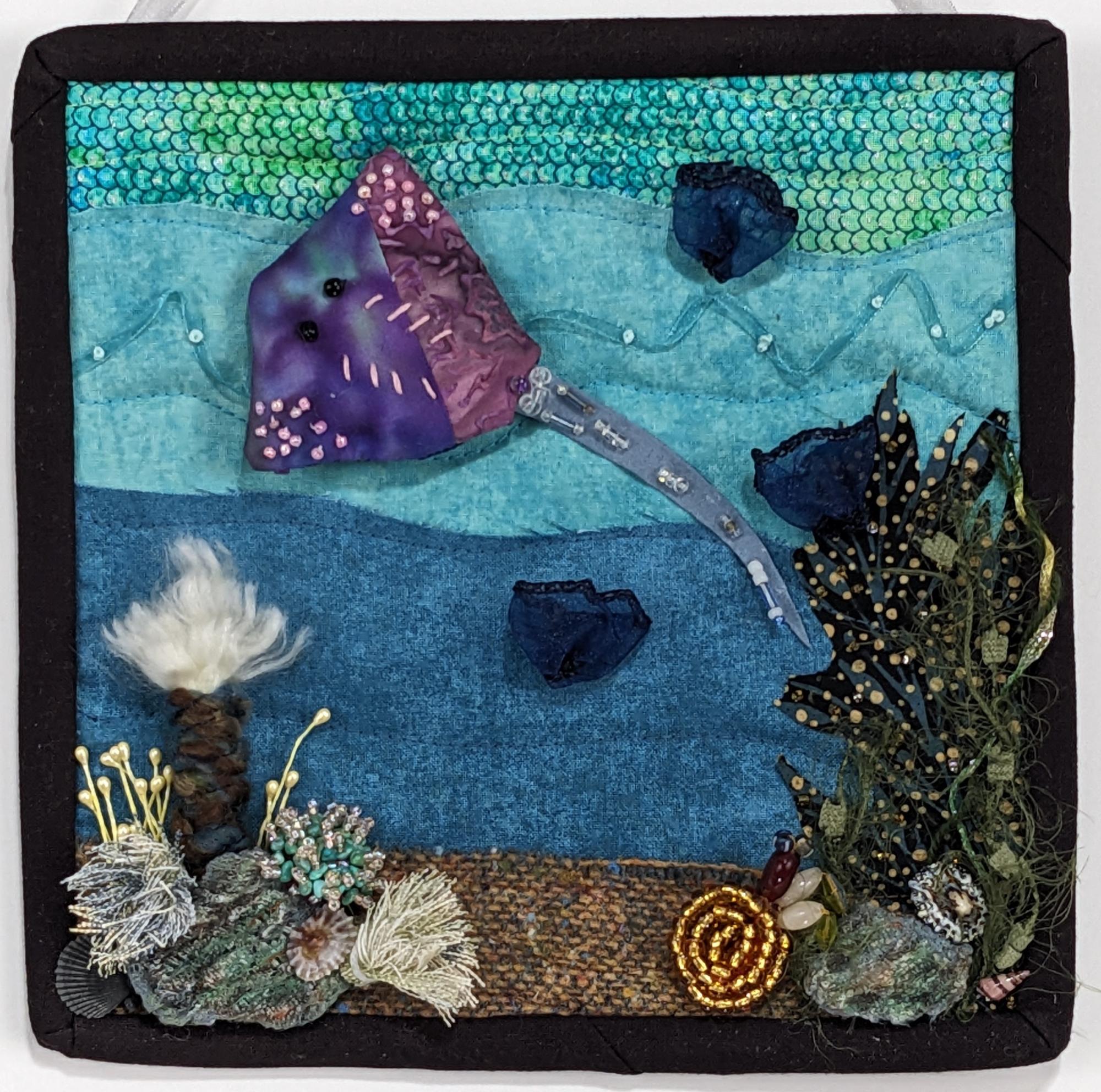 Fabric underwater scene with swimming creatures quilted and beaded.