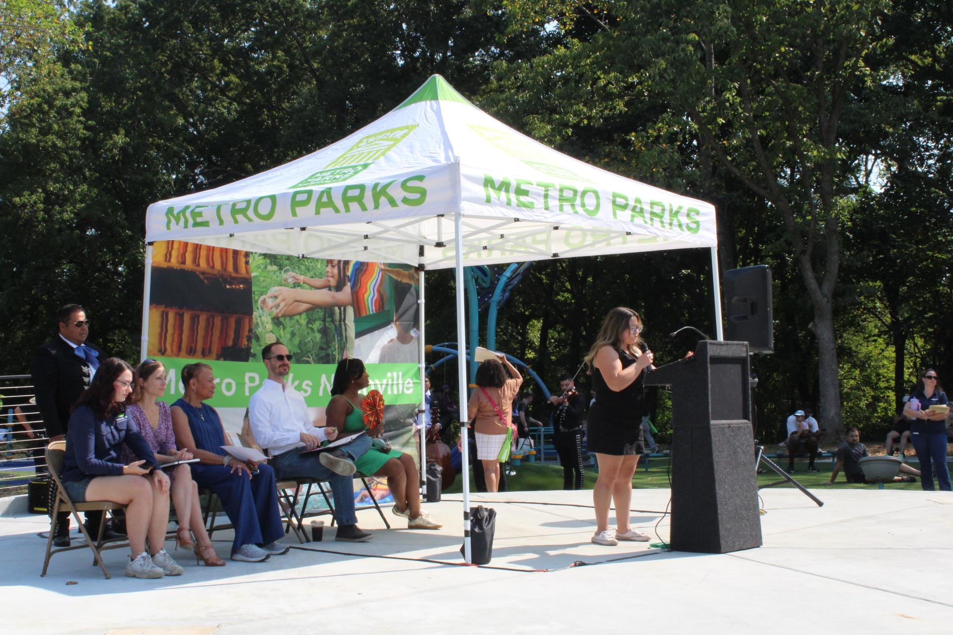 councilwoman speaking under tent at podium