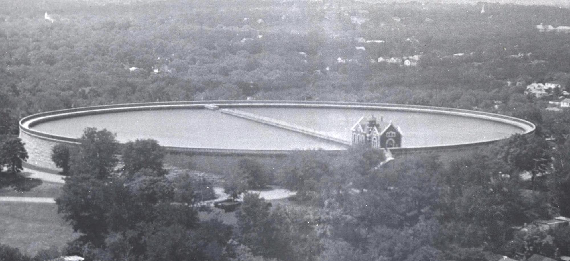 A historical photo of a large basin of water surrounded by trees