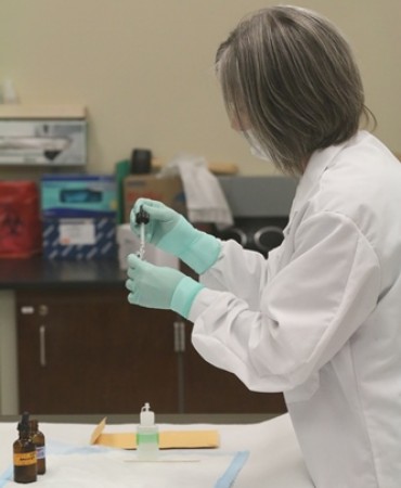 Analyst conducting presumptive testing of blood