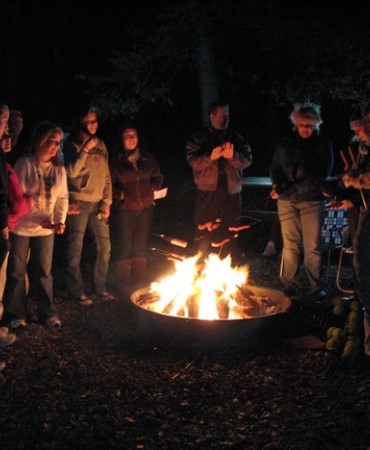 visitors around campfire