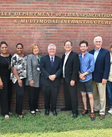 Mayor John Cooper and others standing in front of Department of Transportation sign