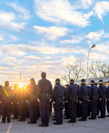 Police Academy trainees in front of flagpole