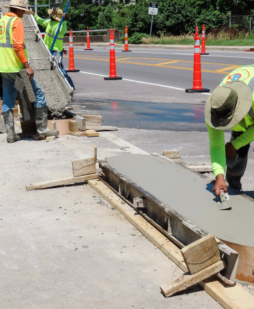 Pouring and smoothing the concrete barriers near 12th Avenue South and Hawkins Street.