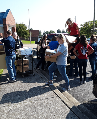 Volunteers hauling school supplies at Amqui School Supply Drive