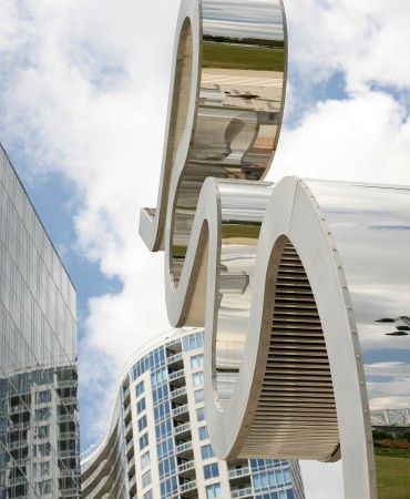 mirrored statue in front of cloudy Nashville skyline