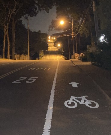 neighborhood bike path, street, and sidewalk at night