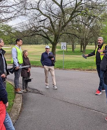group of people talking on a path in a park