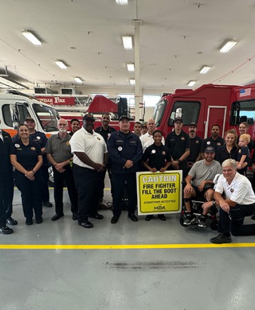 Nashville Fire staff standing in garage with Fill the Boot sign