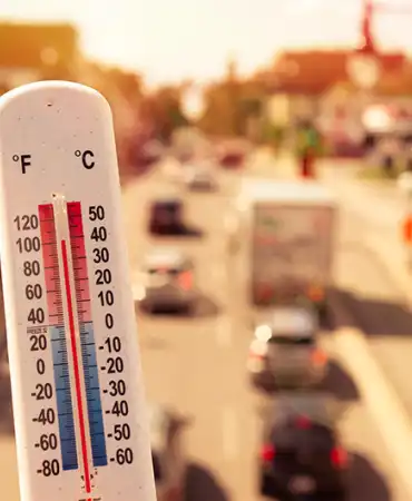 thermometer showing hot temperatures in front of city street