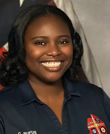 woman poses for a professional headshot in front of american flag
