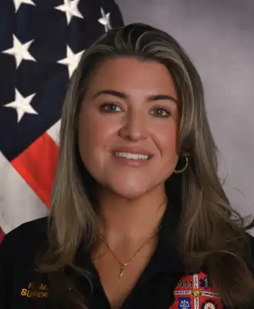 woman poses for a professional headshot in front of american flag