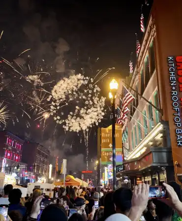 crowd watches fireworks show from the street