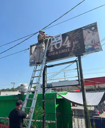 Closed by Court Order sign over 404 Bar billboard