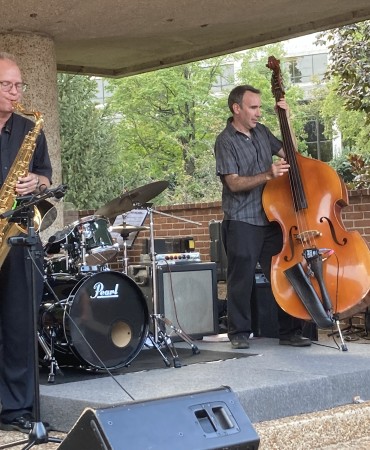 Men playing a saxophone, double bass, and keyboard