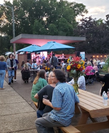 Large crowd gathered to enjoy live music performed under Centennial Art Center acoustic umbrella
